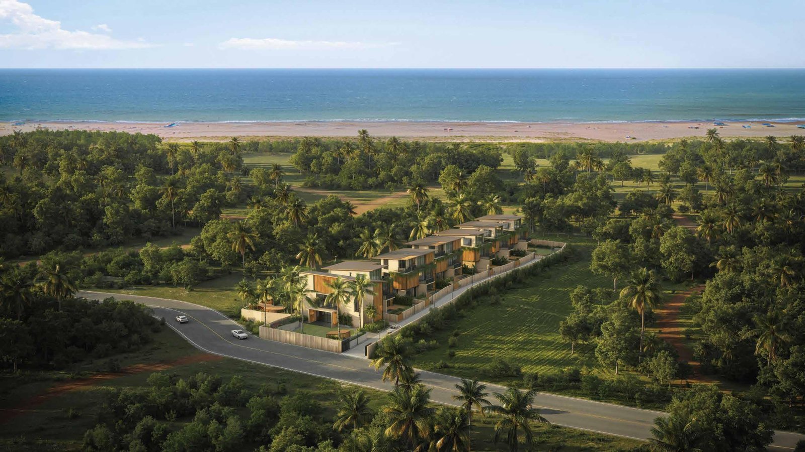 Aerial view of The Sands villas framed by lush tropical landscaping near the coastline